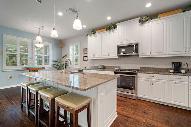 5102 Coastal Scene Dr, Apollo Beach, FL 33572 - kitchen with appliances with stainless steel finishes, a sink, white cabinetry, light stone countertops, and recessed lighting