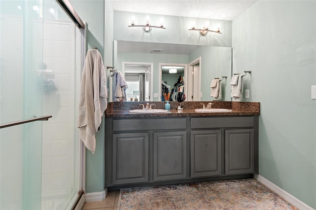 10512 Fuzzy Cattail St, Riverview, FL 33578 - bathroom with a shower stall, a walk in closet, double vanity, baseboards, and a textured ceiling