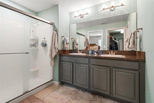 10512 Fuzzy Cattail St, Riverview, FL 33578 - full bathroom featuring a shower stall, a walk in closet, tile patterned floors, double vanity, and a textured ceiling