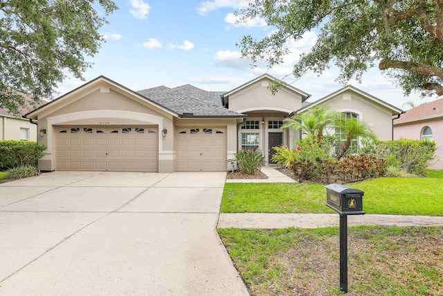 16104 Bridgedale Dr, Lithia, FL 33547 - view of front of home featuring stucco siding, a garage, driveway, a front yard, and a shingled roof
