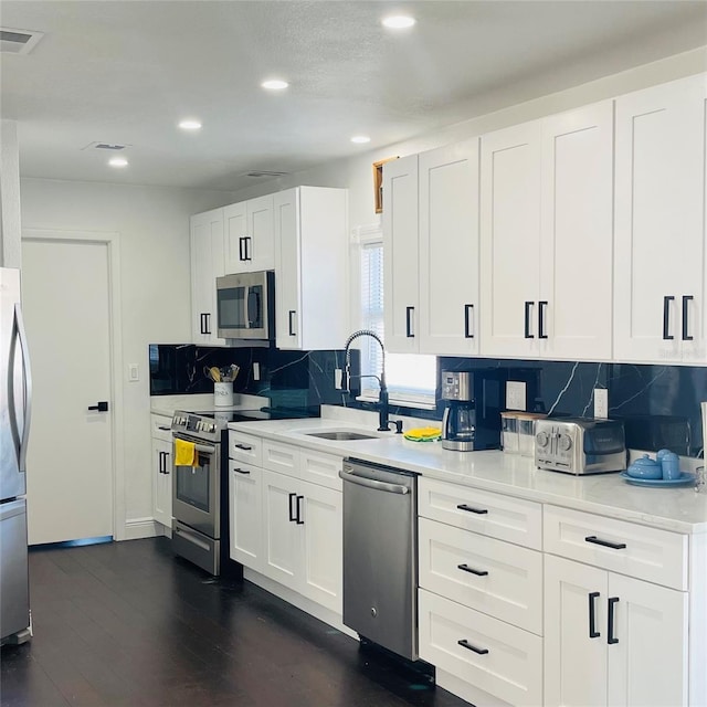 4049 Ponea Dr, Sarasota, FL 34241 - kitchen with appliances with stainless steel finishes, a sink, backsplash, recessed lighting, and white cabinets