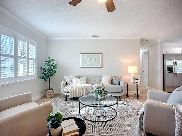 9929 Bay Dr, Gibsonton, FL 33534 - living area with ornamental molding, a textured ceiling, ceiling fan, light wood-type flooring, and baseboards