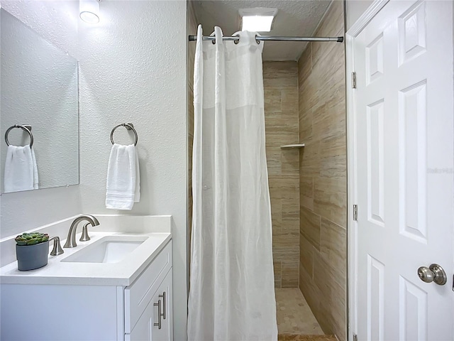 9929 Bay Dr, Gibsonton, FL 33534 - bathroom featuring vanity, a tile shower, and a textured wall