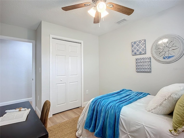 9929 Bay Dr, Gibsonton, FL 33534 - bedroom featuring wood finished floors, ceiling fan, baseboards, a closet, and a textured ceiling