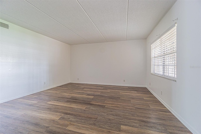 4708 Michael Ct Unit 103, Tampa, FL 33614 - spare room featuring a textured ceiling, dark wood-style flooring, and baseboards