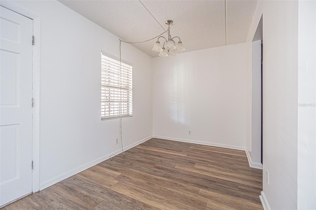 4708 Michael Ct Unit 103, Tampa, FL 33614 - unfurnished dining area with a chandelier, wood finished floors, a textured ceiling, and baseboards