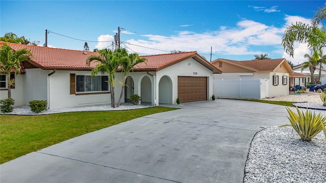 7125 S Shore Dr S, Saint Petersburg, FL 33707 - mediterranean / spanish-style home featuring driveway, an attached garage, stucco siding, and a tile roof