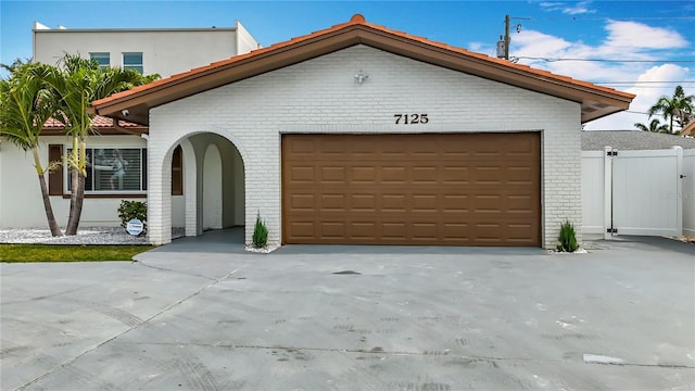 7125 S Shore Dr S, Saint Petersburg, FL 33707 - view of front of home with brick siding, concrete driveway, and a garage