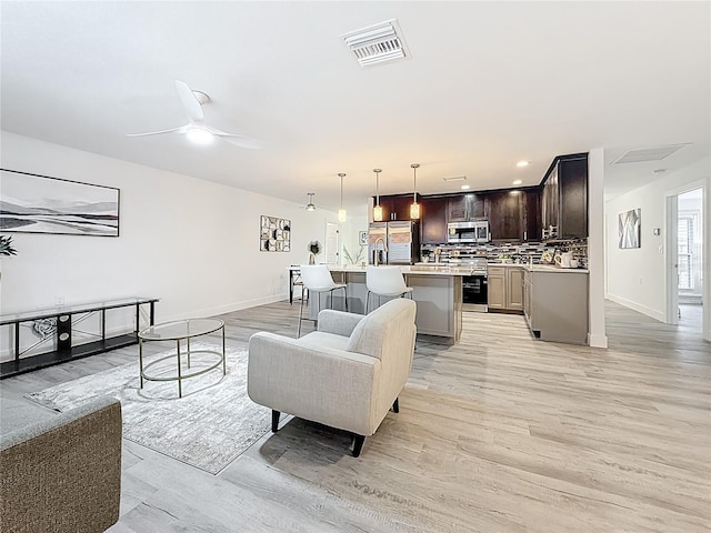 7125 S Shore Dr S, Saint Petersburg, FL 33707 - living area featuring light wood-type flooring, baseboards, ceiling fan, and recessed lighting