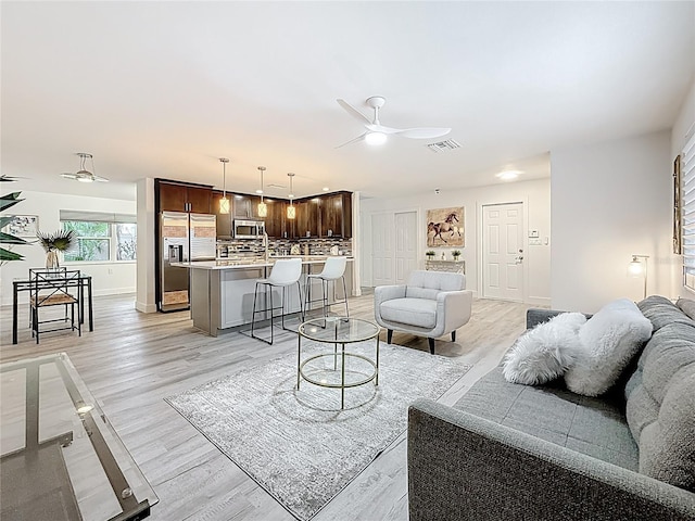 7125 S Shore Dr S, Saint Petersburg, FL 33707 - living room featuring a ceiling fan, light wood-style flooring, and baseboards