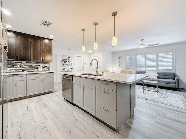 7125 S Shore Dr S, Saint Petersburg, FL 33707 - kitchen featuring a sink, dishwasher, light wood-type flooring, and decorative backsplash