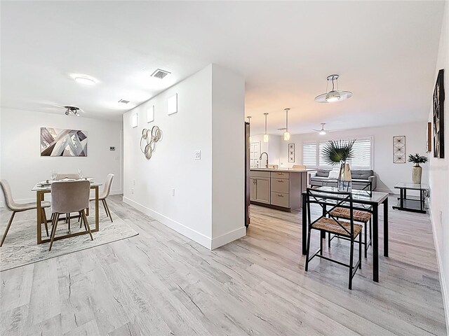 7125 S Shore Dr S, Saint Petersburg, FL 33707 - dining room featuring baseboards, light wood finished floors, and ceiling fan