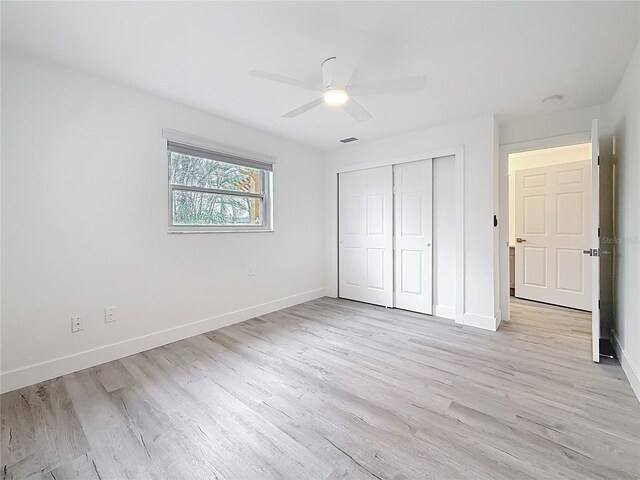 7125 S Shore Dr S, Saint Petersburg, FL 33707 - unfurnished bedroom with light wood-style flooring, baseboards, a closet, and a ceiling fan