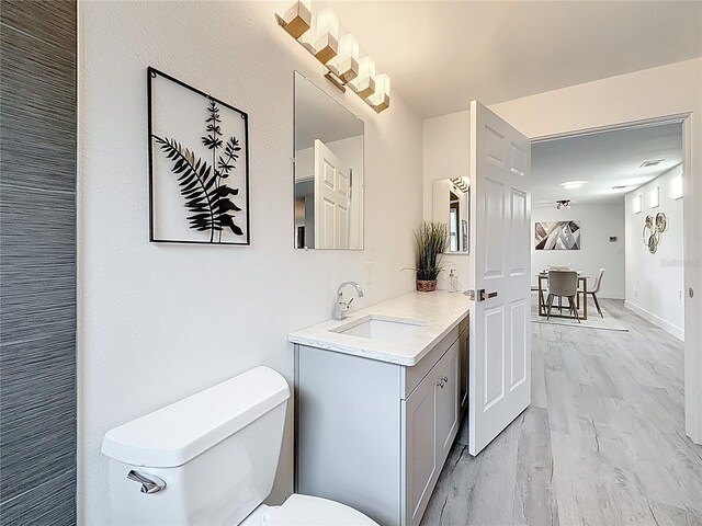 7125 S Shore Dr S, Saint Petersburg, FL 33707 - bathroom with toilet, vanity, and wood finished floors