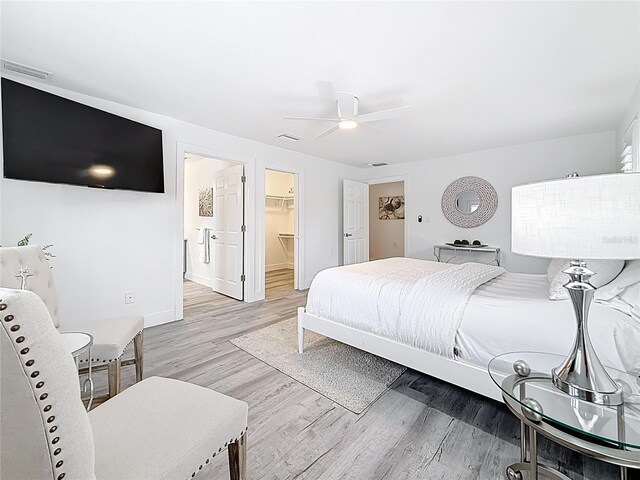 7125 S Shore Dr S, Saint Petersburg, FL 33707 - bedroom with light wood-type flooring, a spacious closet, baseboards, a ceiling fan, and a closet