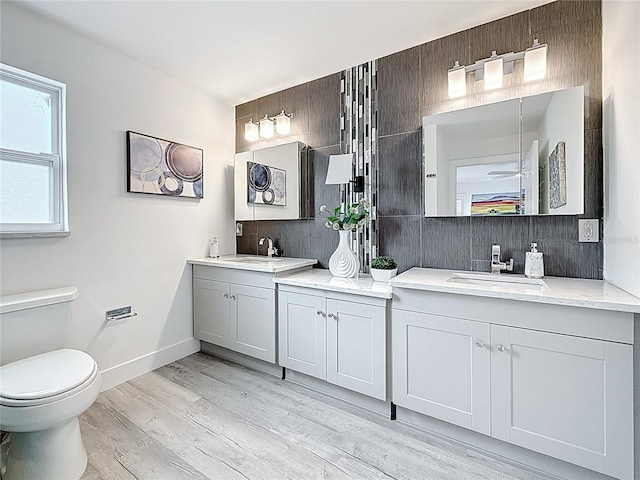 7125 S Shore Dr S, Saint Petersburg, FL 33707 - full bath featuring vanity, backsplash, wood finished floors, and toilet