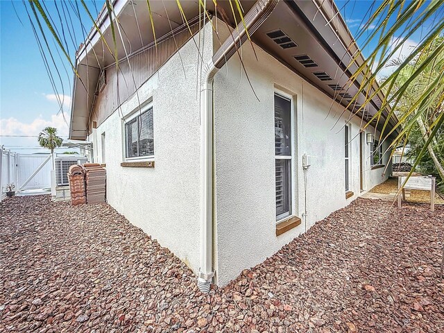 7125 S Shore Dr S, Saint Petersburg, FL 33707 - view of side of property with stucco siding and a gate