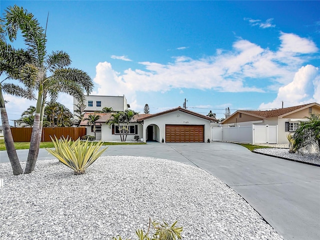 7125 S Shore Dr S, Saint Petersburg, FL 33707 - view of front of home with a garage, driveway, stucco siding, and a gate
