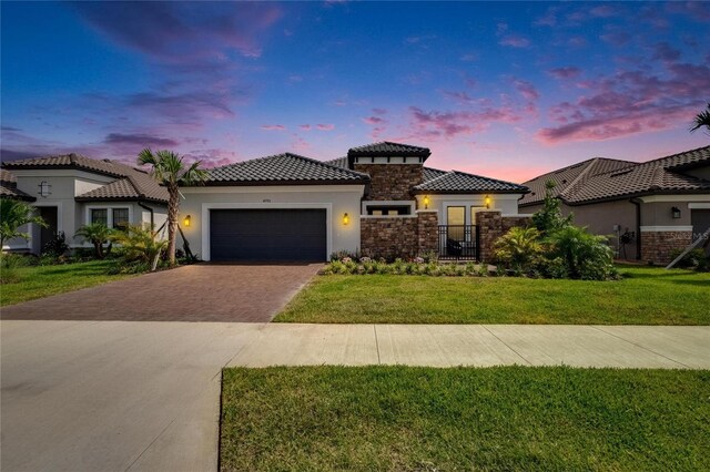 4795 Freccia Loop, Wesley Chapel, FL 33543 - mediterranean / spanish-style house featuring stucco siding, driveway, an attached garage, stone siding, and a tiled roof