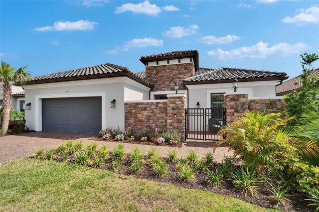 4795 Freccia Loop, Wesley Chapel, FL 33543 - mediterranean / spanish-style home featuring stucco siding, stone siding, a garage, decorative driveway, and a tiled roof