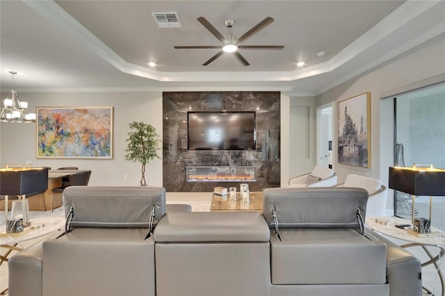 4795 Freccia Loop, Wesley Chapel, FL 33543 - living room with a high end fireplace, a tray ceiling, a ceiling fan, ornamental molding, and a chandelier
