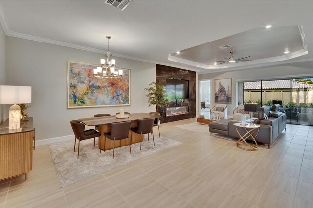 4795 Freccia Loop, Wesley Chapel, FL 33543 - dining space featuring a tray ceiling, a chandelier, baseboards, a ceiling fan, and ornamental molding