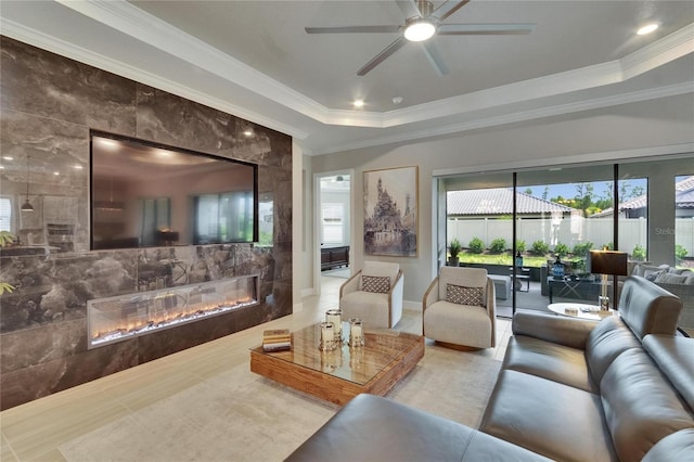 4795 Freccia Loop, Wesley Chapel, FL 33543 - living room with plenty of natural light, a glass covered fireplace, a ceiling fan, ornamental molding, and a raised ceiling