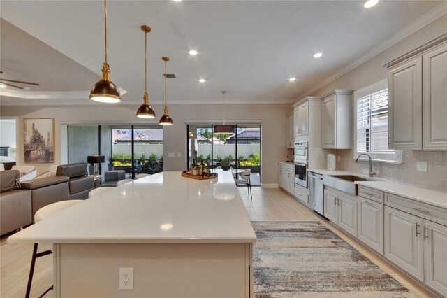 4795 Freccia Loop, Wesley Chapel, FL 33543 - kitchen featuring a sink, a breakfast bar area, open floor plan, stainless steel appliances, and light countertops