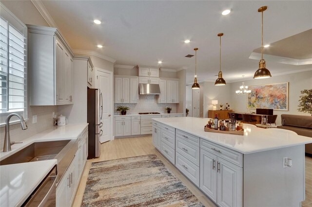 4795 Freccia Loop, Wesley Chapel, FL 33543 - kitchen with freestanding refrigerator, under cabinet range hood, a sink, black gas cooktop, and a large island