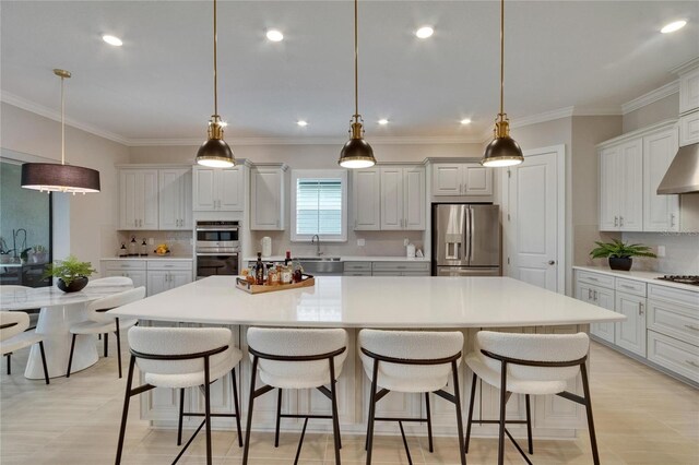 4795 Freccia Loop, Wesley Chapel, FL 33543 - kitchen with appliances with stainless steel finishes, a sink, a spacious island, decorative backsplash, and a kitchen bar