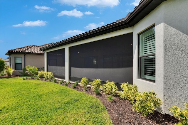 4795 Freccia Loop, Wesley Chapel, FL 33543 - view of side of property featuring stucco siding, a yard, and a sunroom
