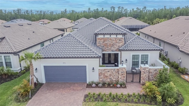 4795 Freccia Loop, Wesley Chapel, FL 33543 - mediterranean / spanish house featuring stone siding, a garage, a tile roof, french doors, and stucco siding