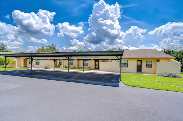 6550 Teak Ct, Zephyrhills, FL 33542 - view of front of house with covered parking, stucco siding, and a front lawn