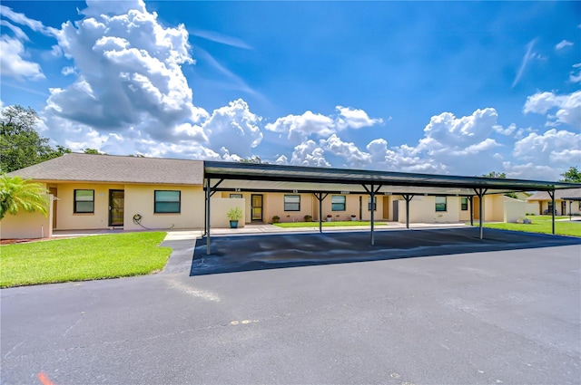 6550 Teak Ct, Zephyrhills, FL 33542 - view of front facade featuring a front lawn, covered parking, and stucco siding