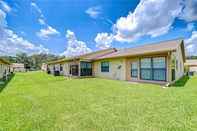 6550 Teak Ct, Zephyrhills, FL 33542 - rear view of house featuring a lawn, stucco siding, cooling unit, and roof with shingles
