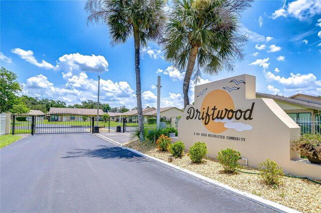 6550 Teak Ct, Zephyrhills, FL 33542 - view of asphalt road featuring a gate, a gated entry, and curbs