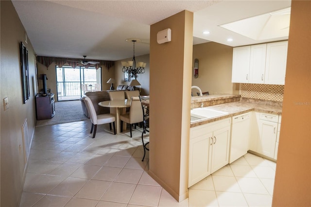 1846 Golfview Dr Unit 1846, Tarpon Springs, FL 34689 - kitchen featuring dishwasher, a sink, light tile patterned floors, tasteful backsplash, and light countertops