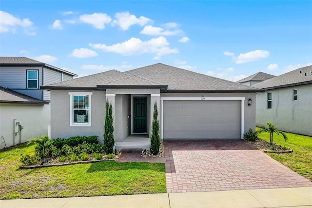 2296 Crossbow St, Clermont, FL 34715 - view of front of property featuring a garage, decorative driveway, stucco siding, a shingled roof, and a front yard