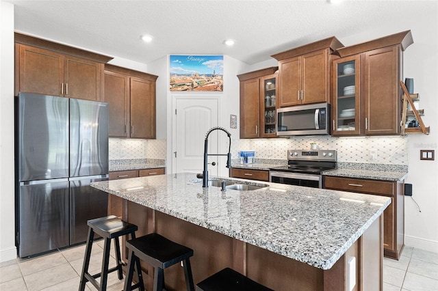 2296 Crossbow St, Clermont, FL 34715 - kitchen featuring stainless steel appliances, a sink, light tile patterned floors, light stone counters, and baseboards