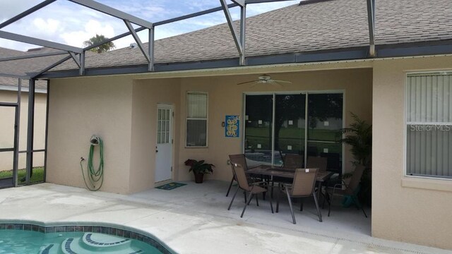189 Minniehaha Cir, Haines City, FL 33844 - swimming pool with a patio area, glass enclosure, a ceiling fan, and outdoor dining area