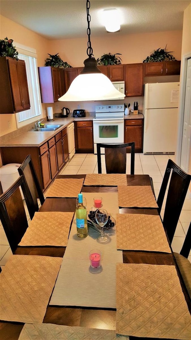 189 Minniehaha Cir, Haines City, FL 33844 - kitchen featuring white appliances, hanging light fixtures, light countertops, a sink, and light tile patterned floors