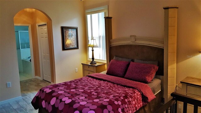 189 Minniehaha Cir, Haines City, FL 33844 - bedroom featuring arched walkways, wood finished floors, and baseboards