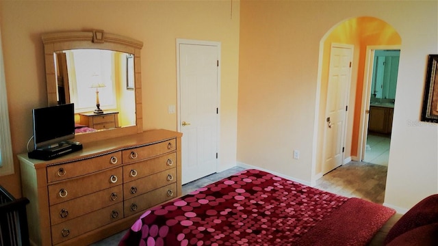 189 Minniehaha Cir, Haines City, FL 33844 - bedroom with arched walkways, wood finished floors, and baseboards