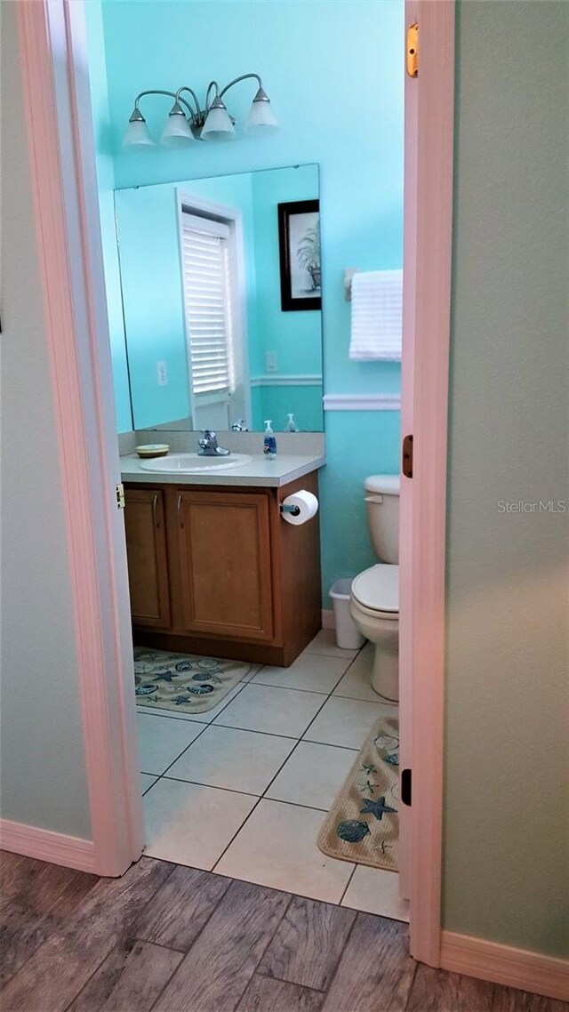 189 Minniehaha Cir, Haines City, FL 33844 - half bathroom with vanity, toilet, wood finished floors, and baseboards