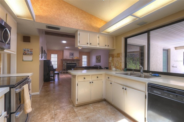 313 Oak Crest Dr, Safety Harbor, FL 34695 - kitchen featuring stainless steel appliances, a sink, light countertops, a stone fireplace, and recessed lighting