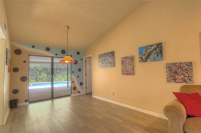 313 Oak Crest Dr, Safety Harbor, FL 34695 - dining room with vaulted ceiling, a textured ceiling, wood finished floors, and baseboards