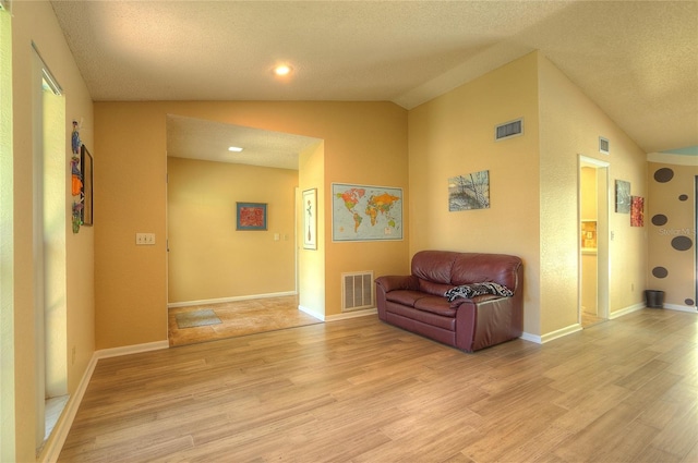 313 Oak Crest Dr, Safety Harbor, FL 34695 - sitting room with vaulted ceiling, light wood finished floors, a textured ceiling, and baseboards