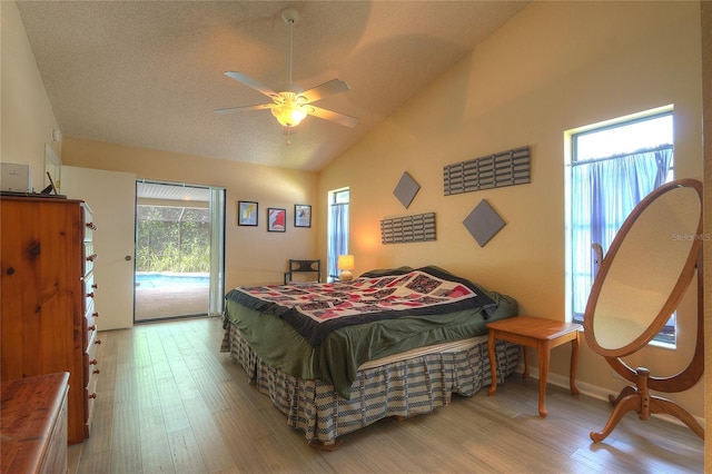 313 Oak Crest Dr, Safety Harbor, FL 34695 - bedroom with lofted ceiling, access to exterior, wood finished floors, a ceiling fan, and a textured ceiling