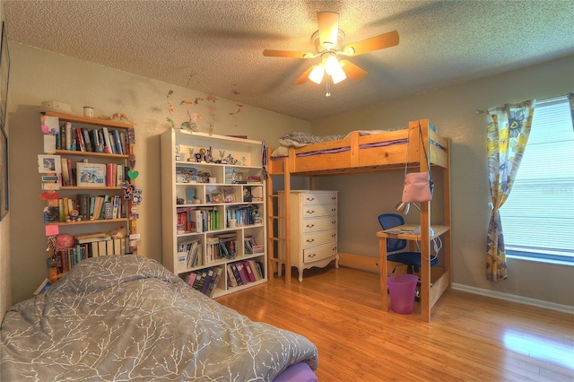 313 Oak Crest Dr, Safety Harbor, FL 34695 - bedroom with wood finished floors, a textured ceiling, baseboards, and a ceiling fan