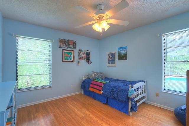 313 Oak Crest Dr, Safety Harbor, FL 34695 - bedroom featuring light wood-style flooring, a textured ceiling, baseboards, and ceiling fan